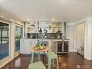 Lower level kitchenette has beautifully appointed granite counters, custom cabinetry, open shelving  and wine fridge that provide both style and functionality.