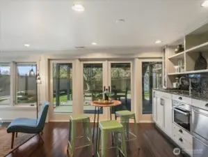 This space includes a well-appointed kitchenette featuring a two-burner cooktop, dishwasher, and sleek two-drawer refrigerator, sink and microwave—perfect for hosting guests with ease.  This level seamlessly blends indoor comfort with outdoor living, creating a private retreat for relaxation or gatherings.