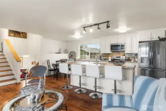 ~Open Concept Main Level Living Room view to oversized island and kitchen with granite counters throughout~