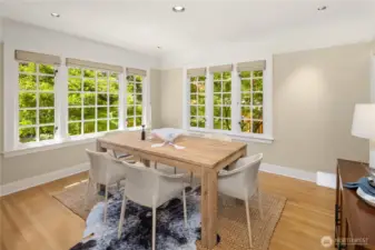 Large corner windows wrap the dining room in greenery.