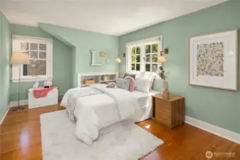 Sunlight, gleaming fir floors, and charming built-ins give this upstairs bedroom a warm, welcoming feel.