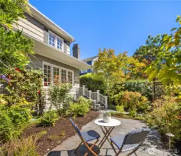 Start your morning—or wind down your evening—on this lovely front patio, nestled among blooming roses and other mature plantings.