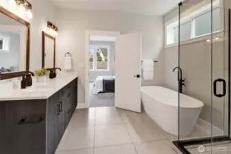 The primary bathroom features large-format ceramic tile, a generous soaker tub, and a double sink vanity—proof that the builder didn’t cut any corners when it came to luxury and quality.