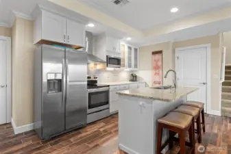 The stove/oven, refrigerator/freezer, microwave and dishwasher in this second kitchen are all included in the sale. The door next to the stairs has deep (under the stairs) storage, and the door to the left of the refrigerator leads to a 6' x 22' storage area which also houses the water heater & furnace.