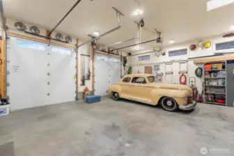 In addition to the attached 2 car garage, there is a three-bay 1128 sq ft garage with shop and half bath. These two doors are 10' tall. Another bay to the left is accessed separately. House has 400 am service; shop has 200 am service.