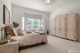 Inviting primary suite, filled with natural light from west facing bay window, creating a warm glow