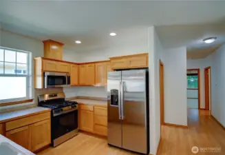 Oak wood cabinets have been refinished and are in pristine condition.