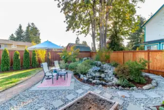 Peaceful water feature with lights provides a relaxing space all year long. Large storage shed with workbench.