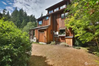 East side of the home. The garden window is at the kitchen sink. On demand water heater is to the left of the garden window and the solar battery is in the paneled box to the right of the window.