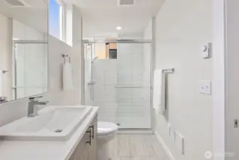 Primary ensuite bathroom with featured trough sink, and walk in tiled shower.