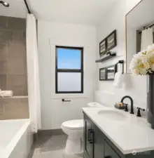 The upper-level full bath is a cozy retreat with stylish fixtures and sleek tiles.