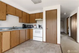 Kitchen is open and bright.  White door on the far right is the front entrance.  The large closet on the right is the coat closet and a big linen, books, games whatever closet