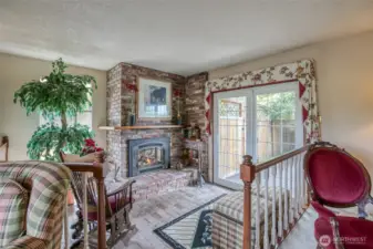 Front room with a propane fireplace for conversation or reading, also a door out to a large wooden deck.