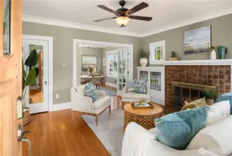 Step inside to a bright living space with hardwood floors, crown molding, and a cozy fireplace that immediately feels inviting.