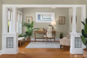 A versatile flex space off the living room doubles as a home office or cozy reading corner, framed by custom millwork.