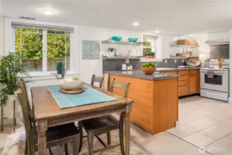 The lower level offers its own stylish kitchen and dining area, complete with granite counters, open shelving, and a bright windowed nook.