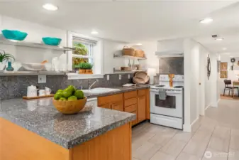 A fully equipped second kitchen with ample cabinetry, updated finishes, and modern lighting provides incredible flexibility for guests or extended stays.