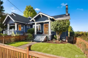 A storybook craftsman exterior with navy siding, crisp white trim, and a welcoming front porch creates timeless curb appeal.