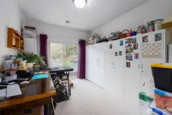 Second bedroom, currently set up as office/craft/storage room, has balcony access.