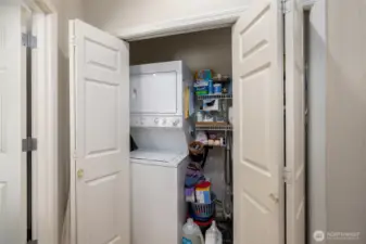 laundry closet in the hall with stackable washer and dryer