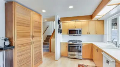 The kitchen is open and light & bright with tons of cabinet space, plus this built-on pantry storage.