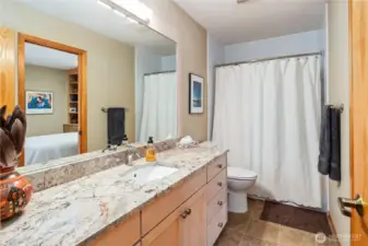 The hallway full bathroom has a door to the hallway, plus a door into the guest bedroom so it can be an ensuite for your overnight guests. Vinyl floors, granite counter, real wood cabinets.