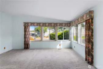 Formal living room is light and bright with all the windows.  The primary suite entry is to the far left.