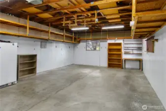 this double car garage has lots of storage shelves ready to go!  with the large driveway to park on, this space could be used for a workshop, or ?