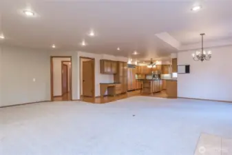A view of the family room and kitchen, notice the flow from the rooms and extensive lighting
