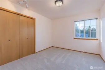 A bedroom, with fresh carpeting and updated lighting