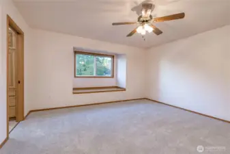 A primary bedroom, with new carpeting and a ceiling fan/light