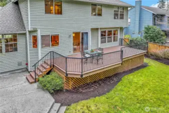 A full view of the home’s exterior reveals the well-maintained siding and large windows that invite natural light inside. The deck seamlessly extends from the main living area, enhancing the home’s entertaining potential.