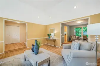 From this angle, the seamless flow into the adjacent home office and entryway is evident. High ceilings and recessed lighting add to the sense of space and sophistication.