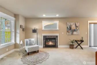 Fireplace in front of home with large windows.