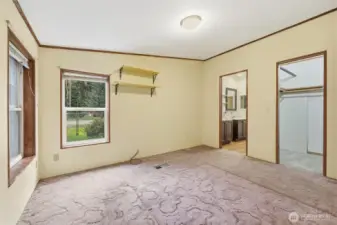 Primary bedroom showing bathroom and walk in closet
