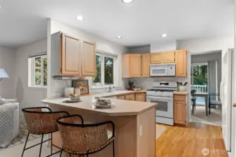 Warm spacious kitchen with expansive countertop and bar aids in gatherings and homecooked meals.