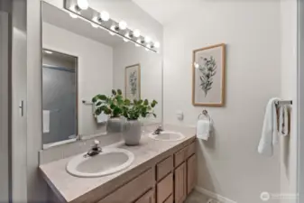 Primary bath with excellent lighting paired with dual-vanity and quality storage.