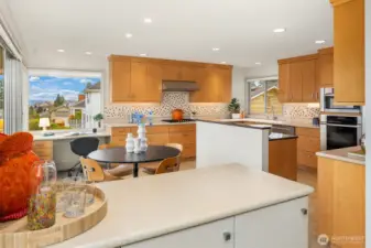 Hard to imagine a more functional (or fun!) kitchen layout.  Casual eating space?  Check.  Homework/home-office station with a view? Check.  Tons of cabinet/counter space with ample room for multiple bodies?     Check.  Check.  Check.