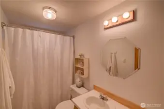 Guest bathroom is complete with shower/tub combo.