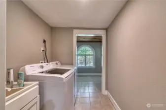 The large utility room with deep sink attaches to large mud room.