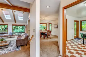 Off entry, living room to the left with vaulted ceilings and skylights.  Dining room center, kitchen to the left.