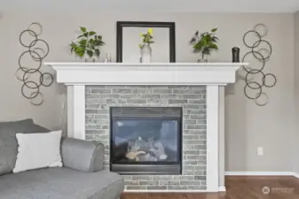 Tile wraps the gas fireplace with wooden mantle and surround.