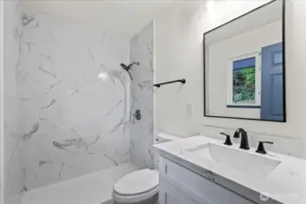 En-suite bathroom with tile surround, walk-in, zero-curb shower.