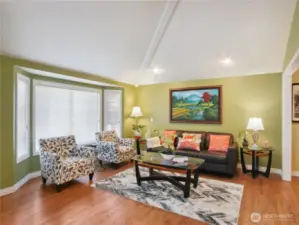 Living room features garden windows and gleeming hardwood floor.