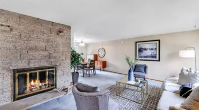 The charming brick fireplace adds classic style and inviting ambiance, seamlessly connecting the living room to the dining area for easy flow and cozy gatherings