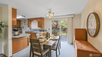 The dining area and kitchen effortlessly flow to the outdoor deck through sliding glass doors that also fill the space with natural light
