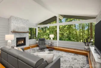 The inviting living room features a cozy fireplace as its focal point and a picture window that frames