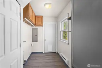 Off the kitchen is the utility room with storage cabinets and access to the back deck through the door in the center. LVP flooring in here makes for easy maintenance!