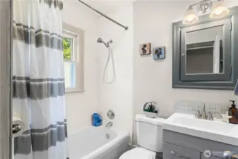 This full bath features 2 built-in storage cabinets, an updated vanity and toilet, and resurfaced bathtub in 2021.