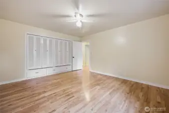 Bedroom one with built in closets and hardwood floors